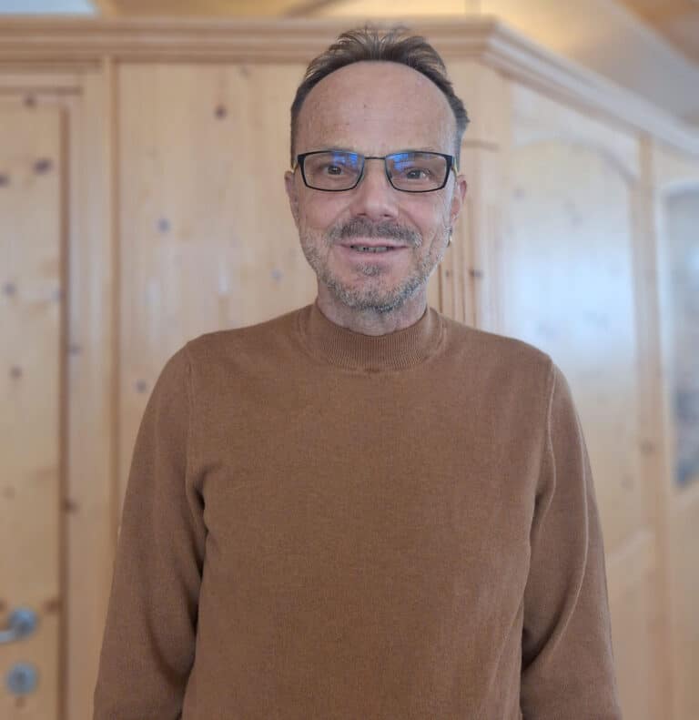 Klaus Sailer im Familienhotel Sailer Stefan Hochzeiger Haus vor einem Bauernschrank aus Holz