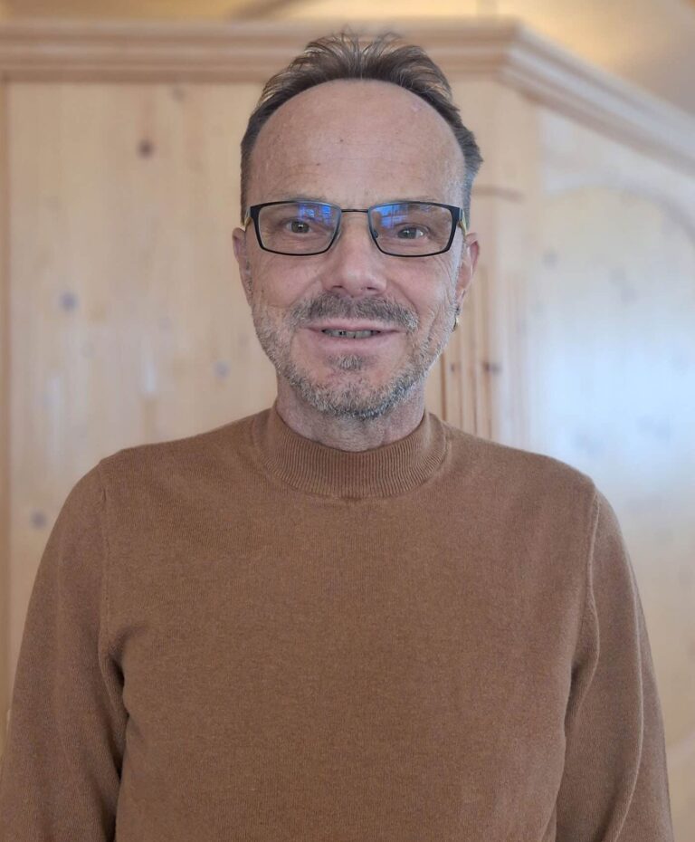 Klaus Sailer im Familienhotel Sailer Stefan Hochzeiger Haus vor einem Bauernschrank aus Holz